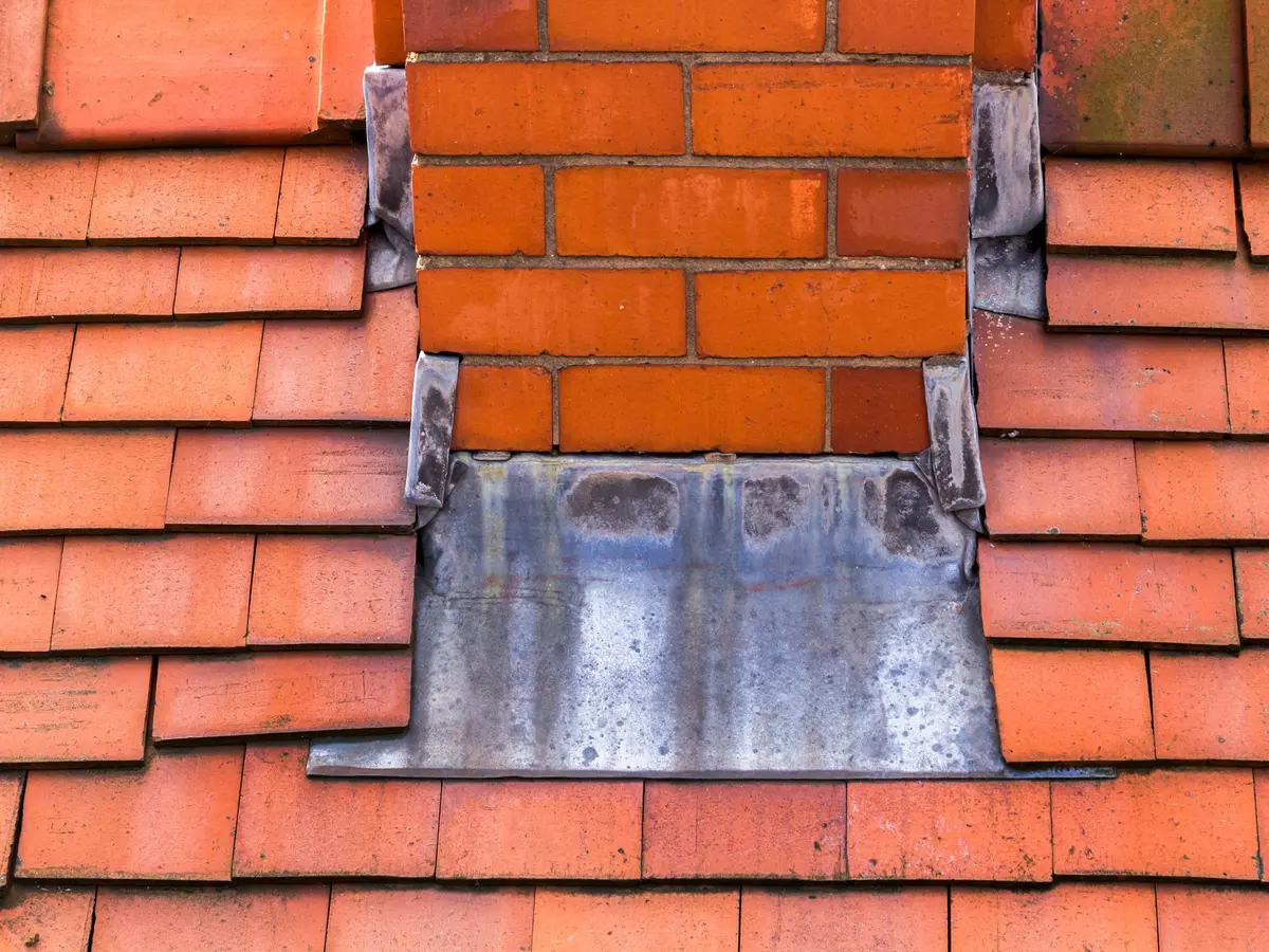 Lead flashing around a chimney on a clay tiled roof