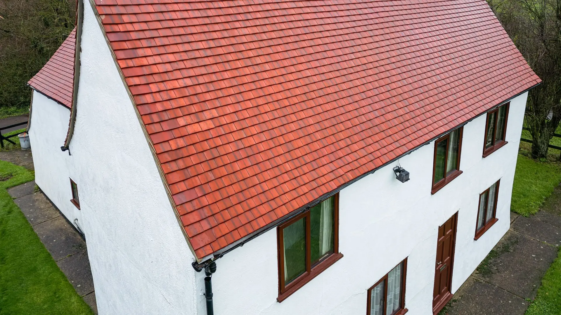 Finished red clay tile roof on a white cottage