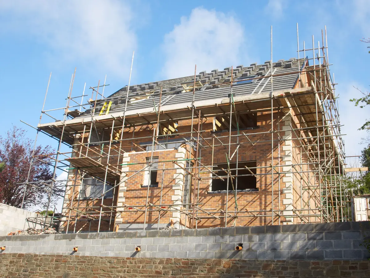 New-build house on scaffolding with its new roof going on