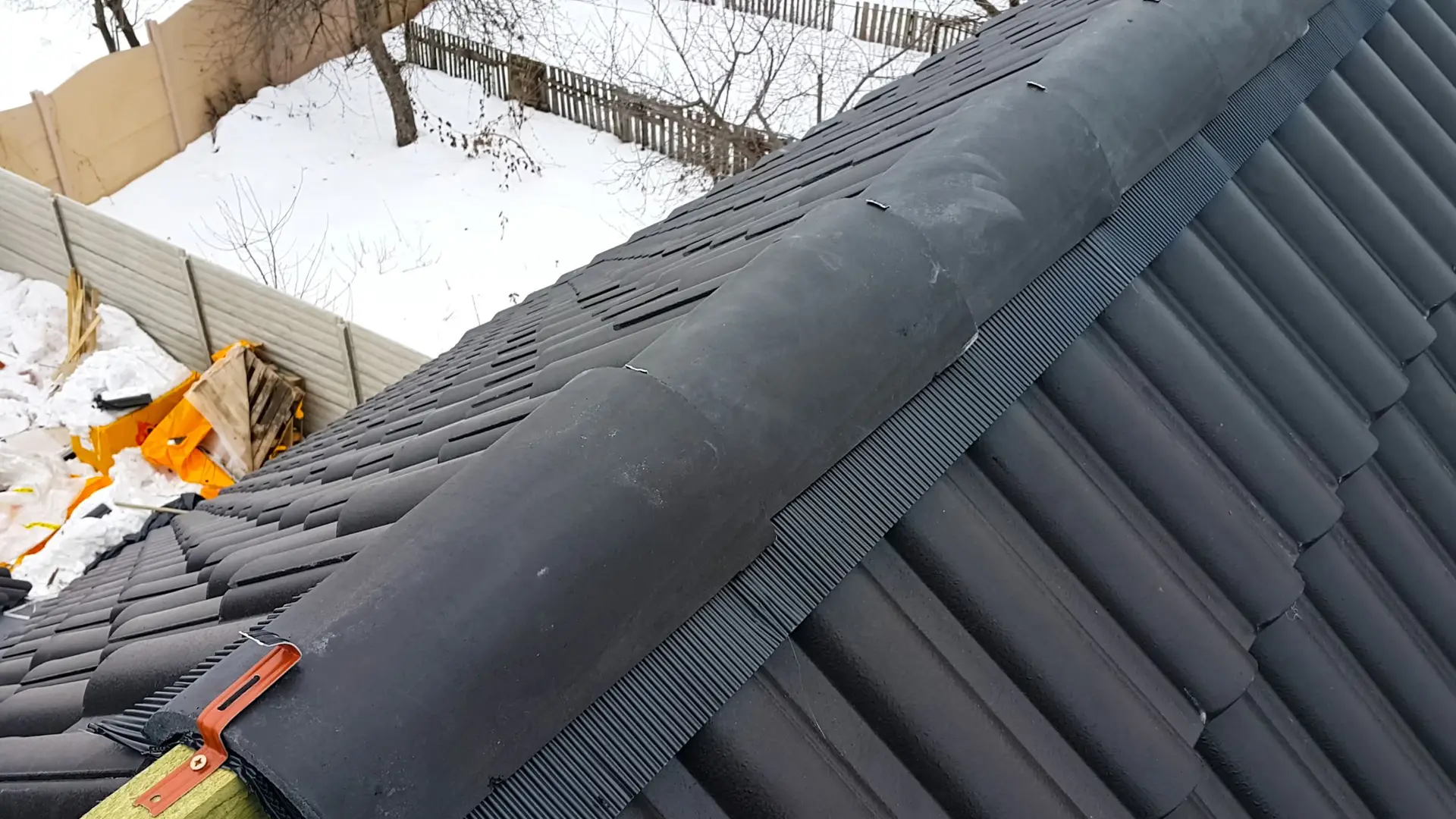 Dry ridge system fixed to a dark tiled roof