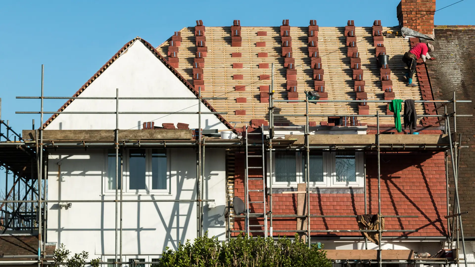 House on scaffolding during a full re-roof with new battens and tiles