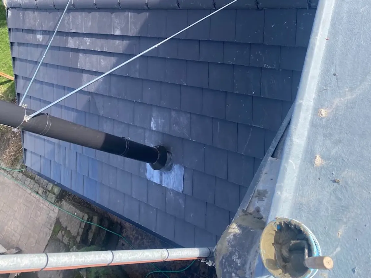 Newly slated roof with a vent pipe, seen from the scaffold